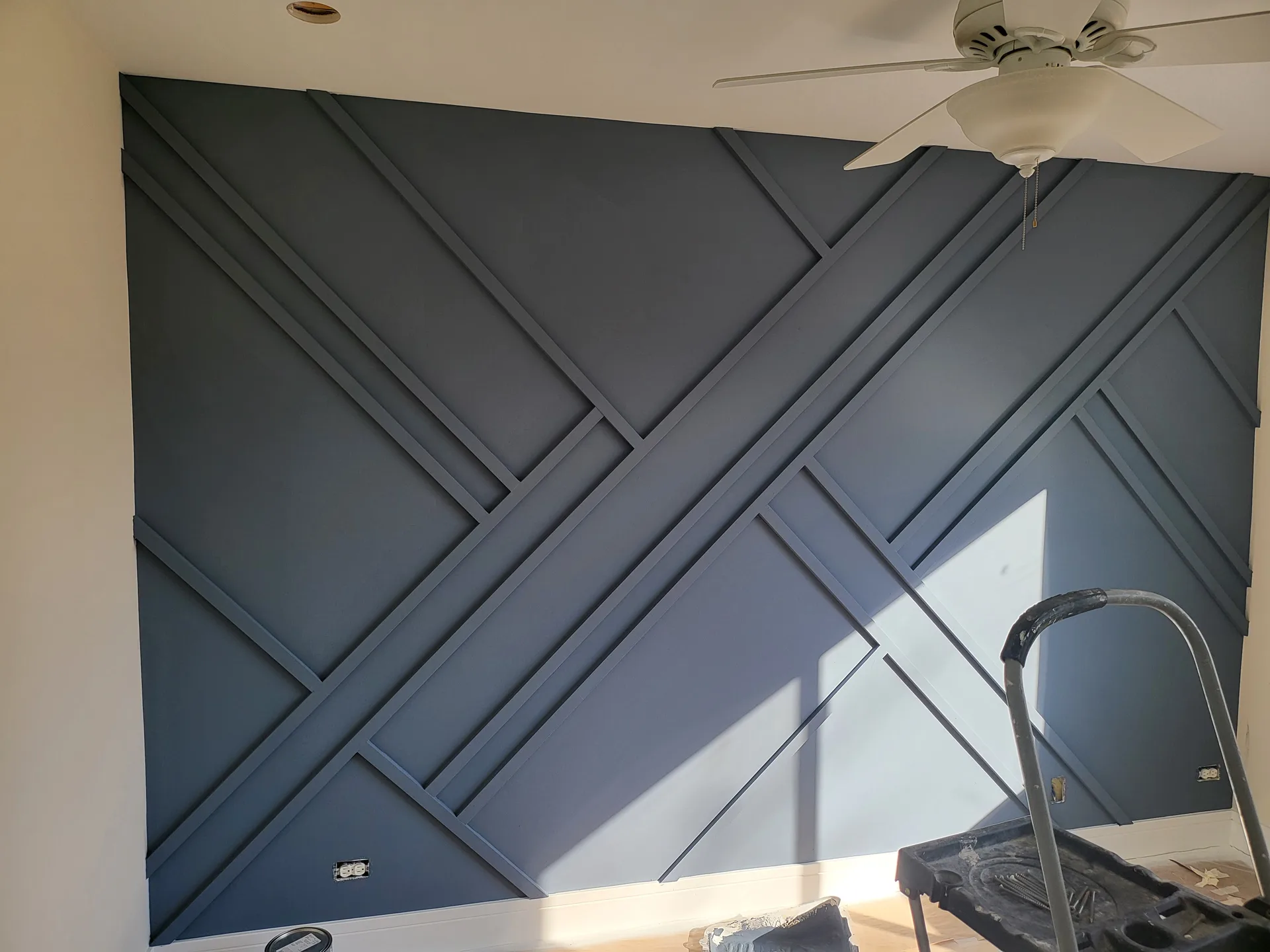 Geometric navy slat wall in a bedroom, before inlays