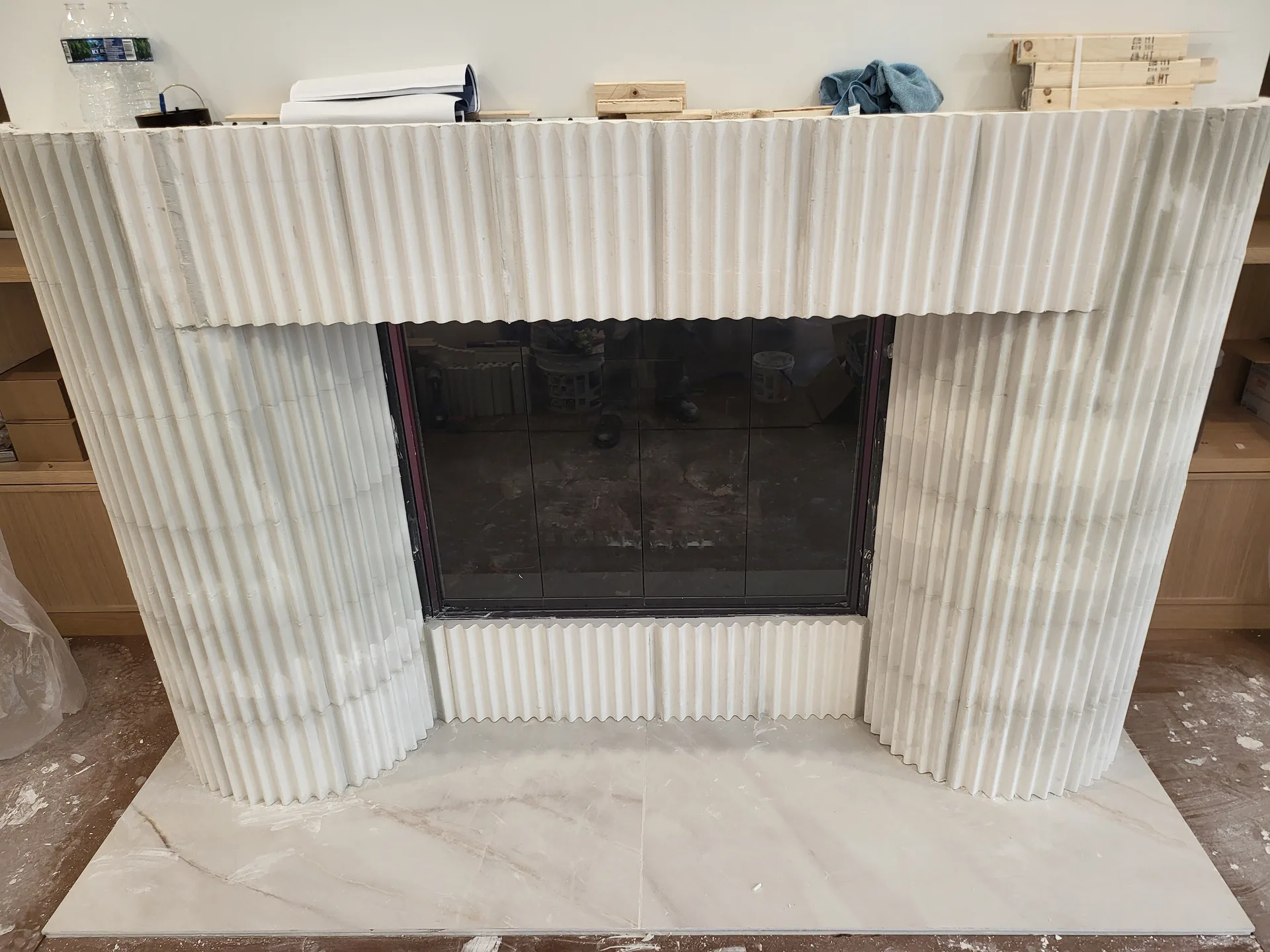 Fluted fireplace surround alongside built-in shelving